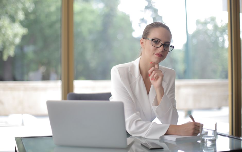 Two people talking across a table in a bright office setting